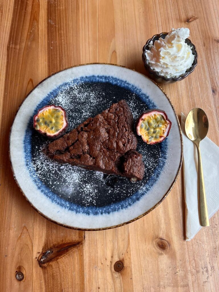 Part de brownie aux noix de pécan, noisettes et beurre salé avec chantilly et fruit de la passion, Thieyp