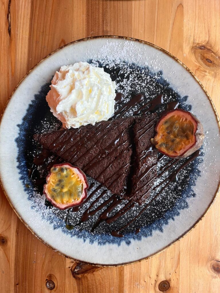 Part de moelleux au chocolat et banane, chantilly et fruit de la passion, dessert du Thieyp à Ixelles
